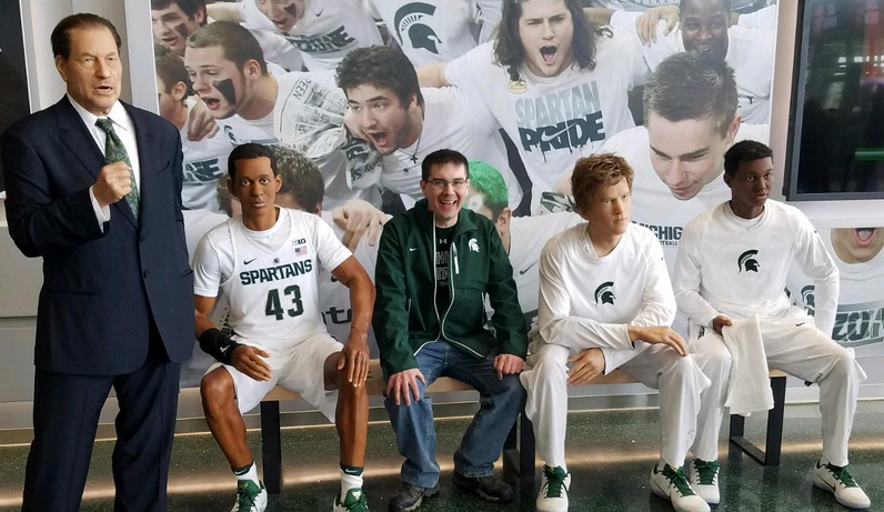 man sitting in sports wax museum