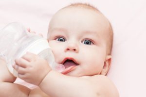 baby holding bottle