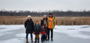 photo of a family standing on a frozen pond